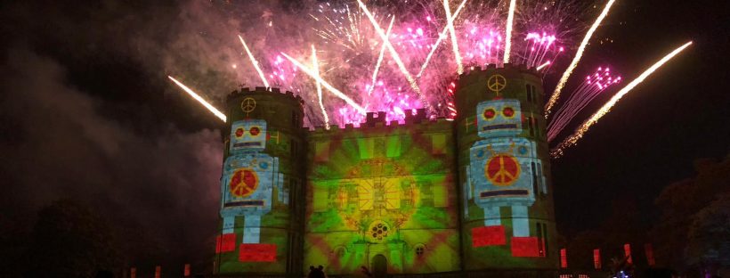 The LoveBot image is projected onto Lulworth Castle during the beautiful fireworks display, image shows fireworks exploding over the top of the castle at Bestival