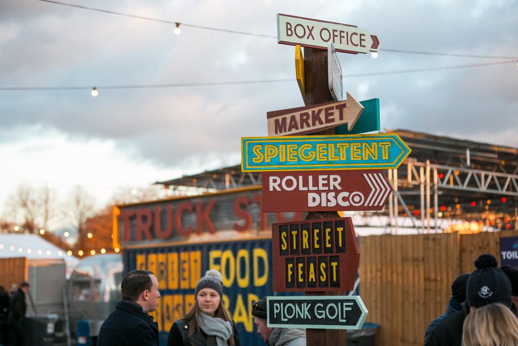The signpost at Winterville winter festival, showing the direction to the different areas including Spiegeltent, Street Feast, Plonk Golf, the market and more