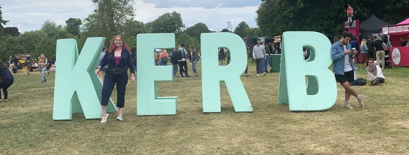 Me stood by the large mint green KERB sign in the Jam on Rye field