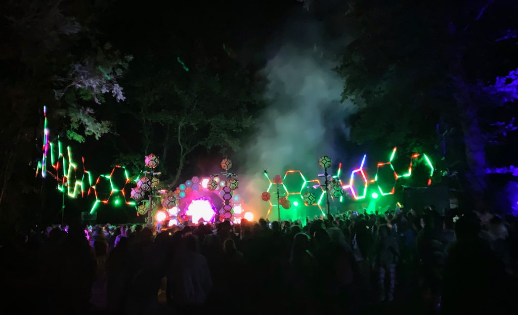 The incredible Liquid Stage lit up at night. The stage is made from lots of hexagon shapes and LED hexagon hoops, making it look like a beehive somewhat?